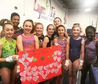 Group of girls holding red sheet with pink hearts